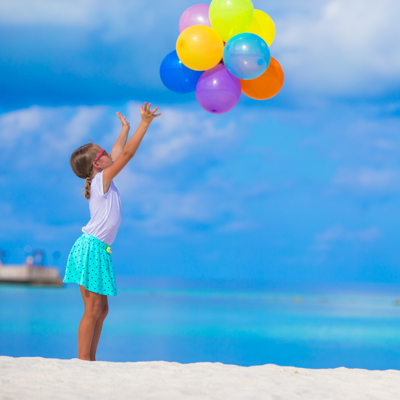 Mädchen lässt Luftballons fliegen